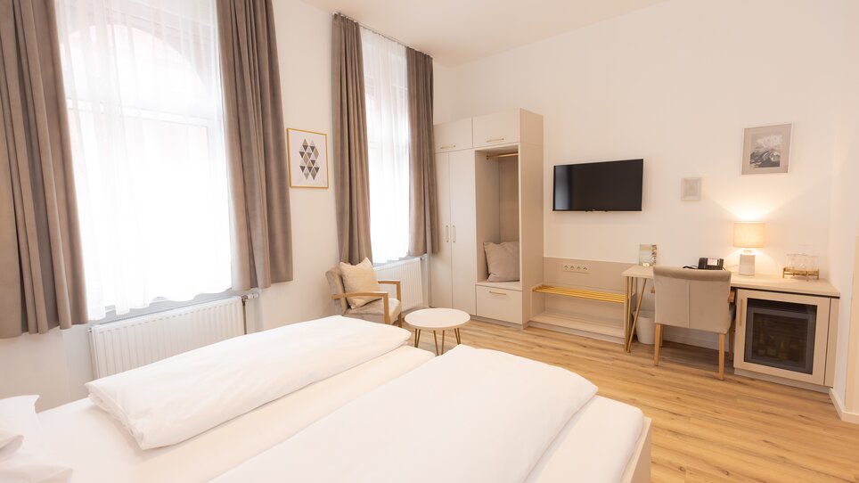 Bright room featuring wooden beds and elegant furniture at Hotel Gollner. | © Hotel Gollner