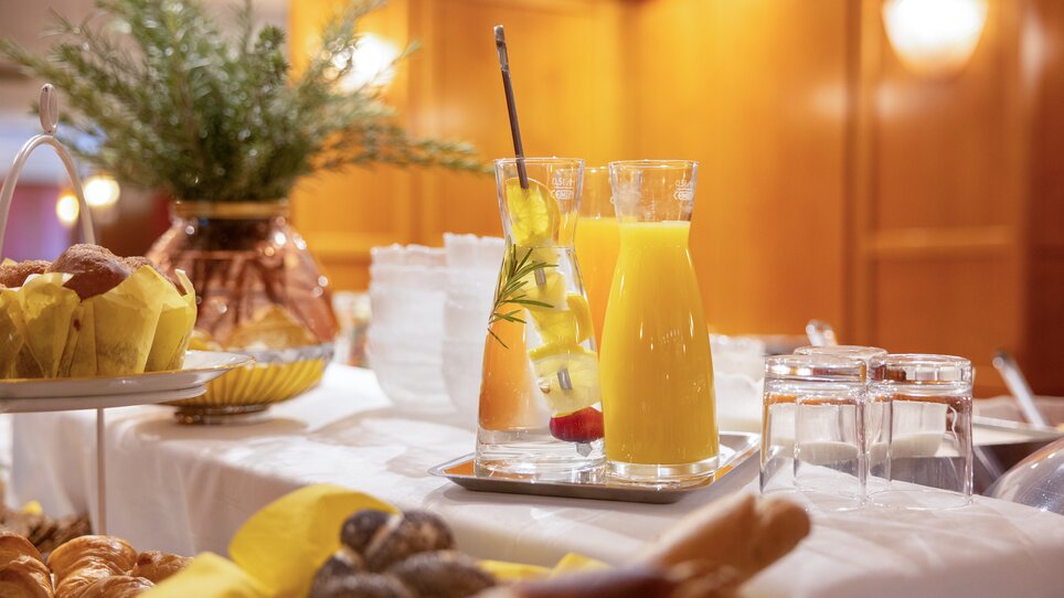 A table set outdoors for breakfast with bread, cold cuts, fruits, and juice at Hotel Gollner. | © Hotel Gollner