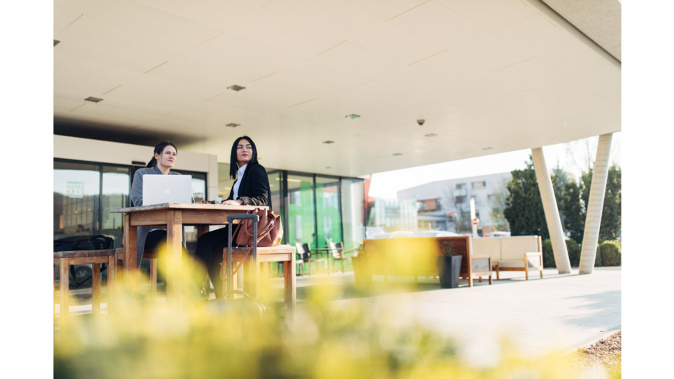 Two women at a business meeting outside, location harry's home Hart bei Graz. | © harry’s home hotels - Daniel Zangerl