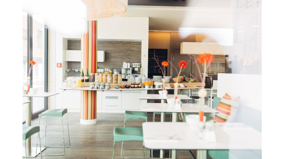 The breakfast room at harry's home Hart bei Graz with a buffet and tables for guests. | © harry’s home hotels - Daniel Zangerl