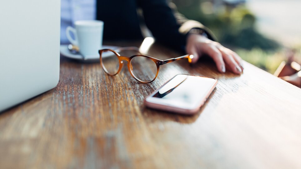 Close-up of a business meeting with laptop, glasses, and smartphone on the table at harry's home hotel Hart bei Graz. | © harry’s home hotels - Daniel Zangerl