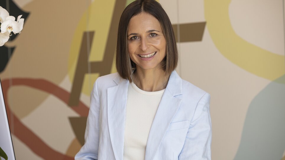 Eine Geschäftsfrau lächelt im Hi5-Hotel Seiersberg. Helle Umgebung. | © Hi5-Hotel Seiersberg