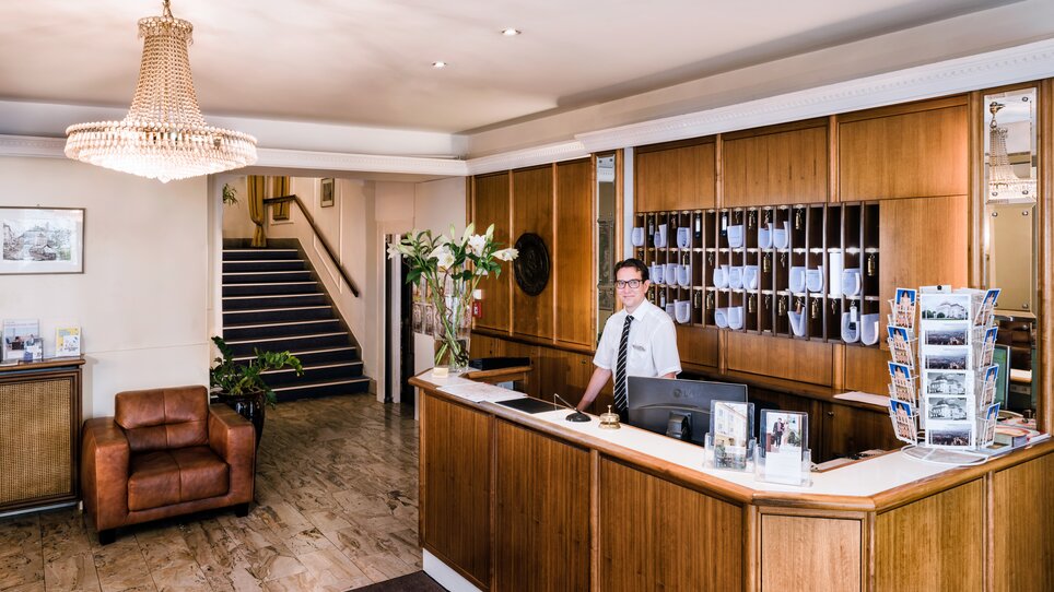 Ein freundlicher Rezeptionist an der Rezeption des Hotel Mariahilf in Graz, ideal für Geschäftsreisen. | © Hotel Mariahilf