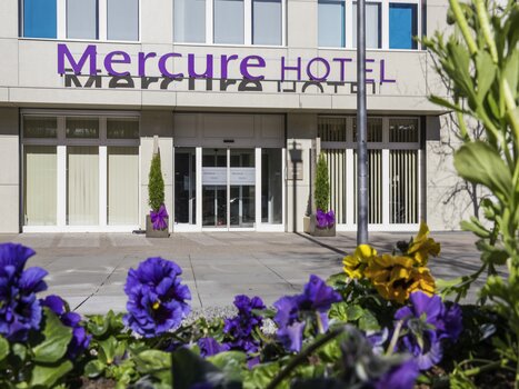 Moderner Eingangsbereich des Mercure Graz City Hotels mit Blumenbeeten. | © Die Steirerin
