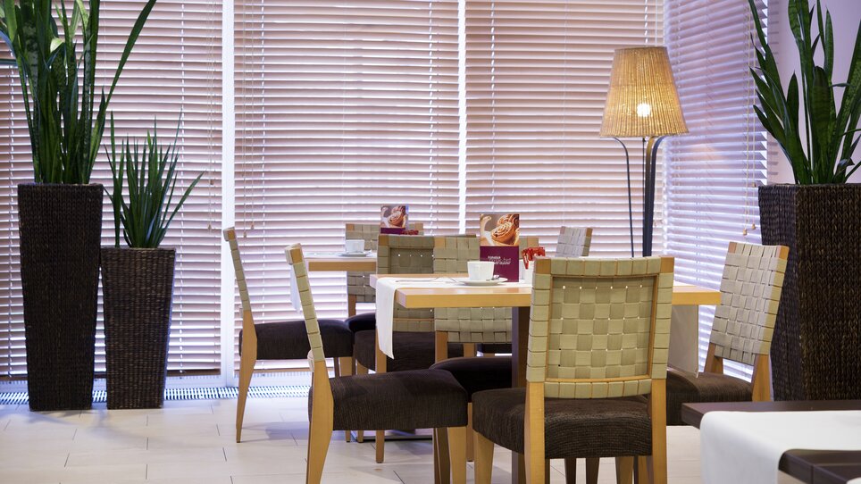 Eine elegante Restaurantumgebung mit Pflanzen und stilvollen Tischen im Hotel Mercure Graz City. | © Mercure Graz City - Rudolf Schmied