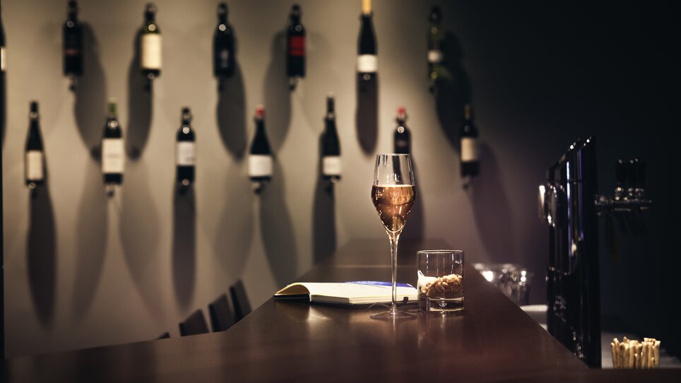 Ein Glas Sekt, ein Whiskyglas mit Snacks und ein Buch auf der Bar des Hotel Mercure Graz City. | © Mercure Graz City - Abaca Corporate - Mitja Kobal