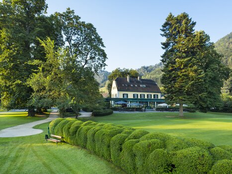 Idyllic view of Murhof Hotel & Restaurant surrounded by trees and manicured gardens. | © Murhof Hotel & Restaurant