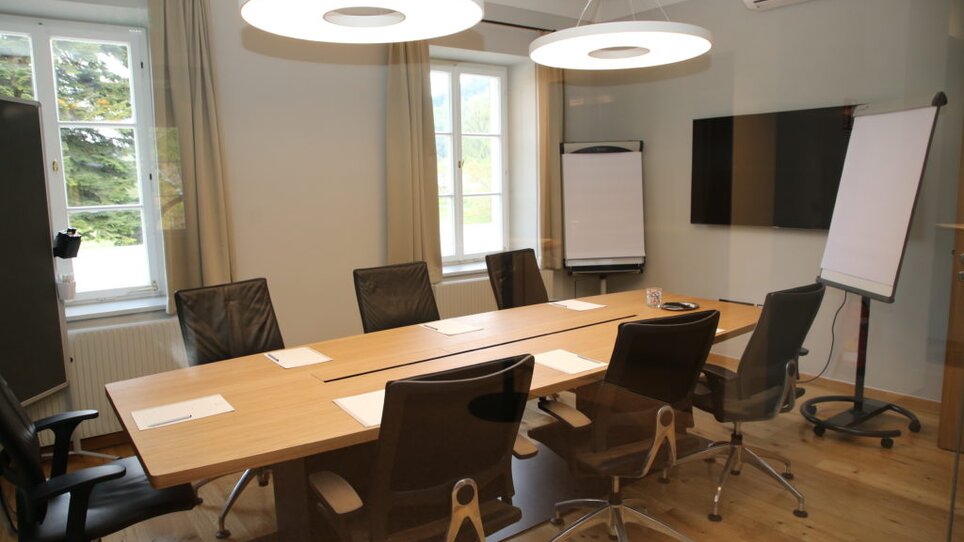 Interior of a conference room with wooden elements and business meeting setup at Murhof Hotel & Restaurant. | © Murhof 