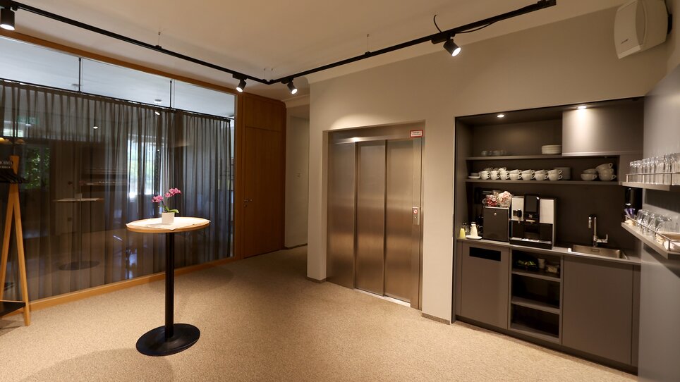 Elegant foyer with dining area and elevator, ideal for business meetings at Murhof Hotel & Restaurant. | © Murhof