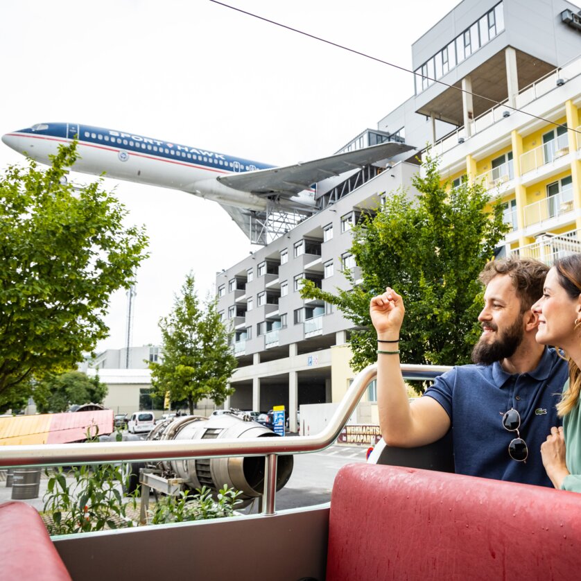 Couple at Novapark aircraft hotel with an airplane in the background. | © Graz Tourismus - Werner Krug