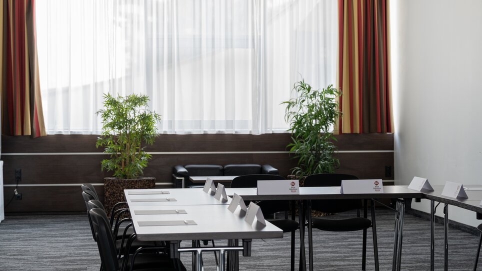 Ein Raum für geschäftliche Treffen mit Tisch, Stühlen und Pflanzen im PLAZA INN Graz Cityz. | © PLAZA INN Graz City