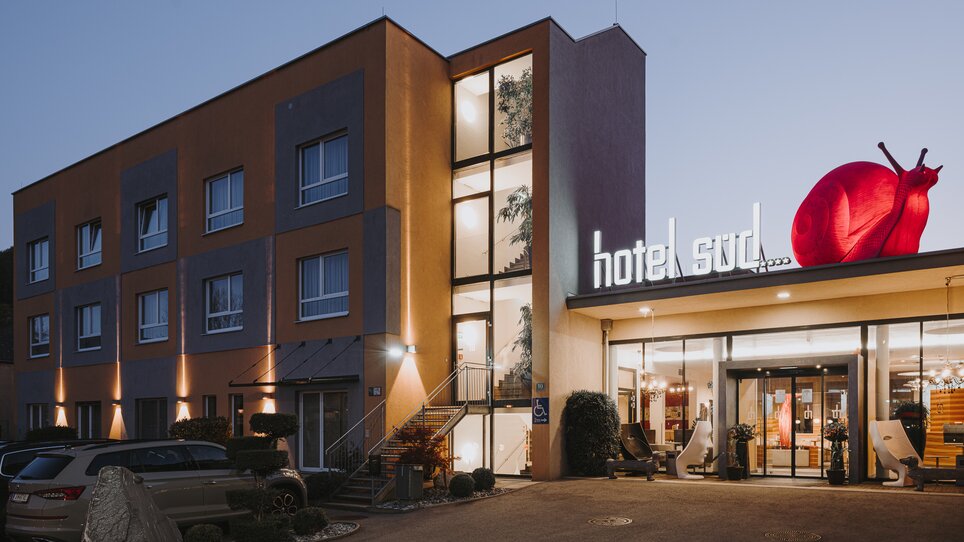 Außenansicht des Hotel Süd mit pinkfarbener Schnecke und Unterstützung für Businessreisen. | © Hotel Süd