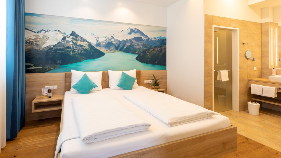 Helles Hotelzimmer mit Bergwand und modernem Bad im Hotel Süd. | © Hotel Süd Art