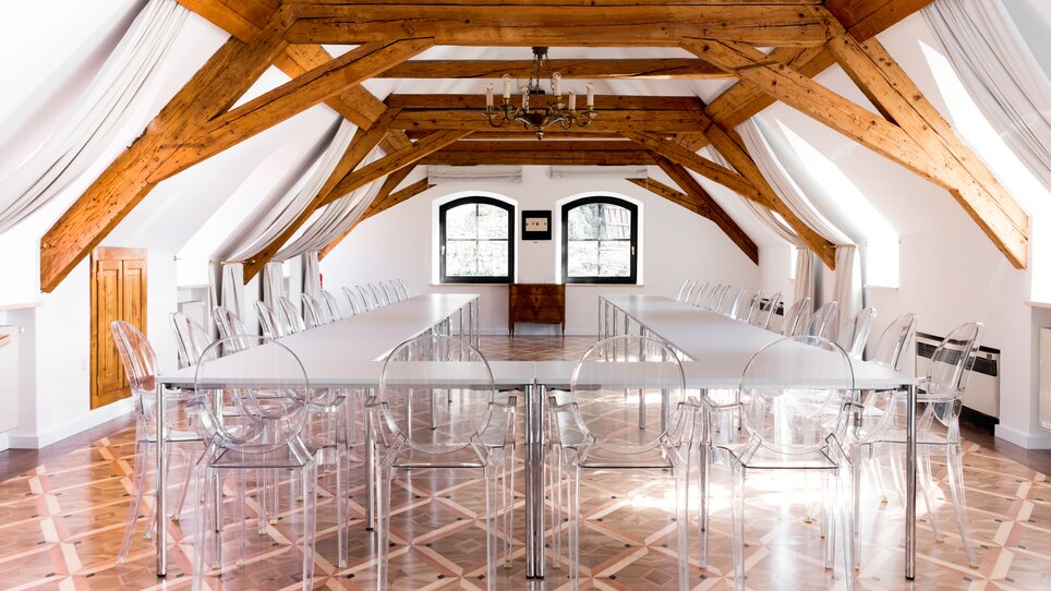 Bright meeting room in Schlossberghotel with chairs and a long table. | © Schlossberghotel