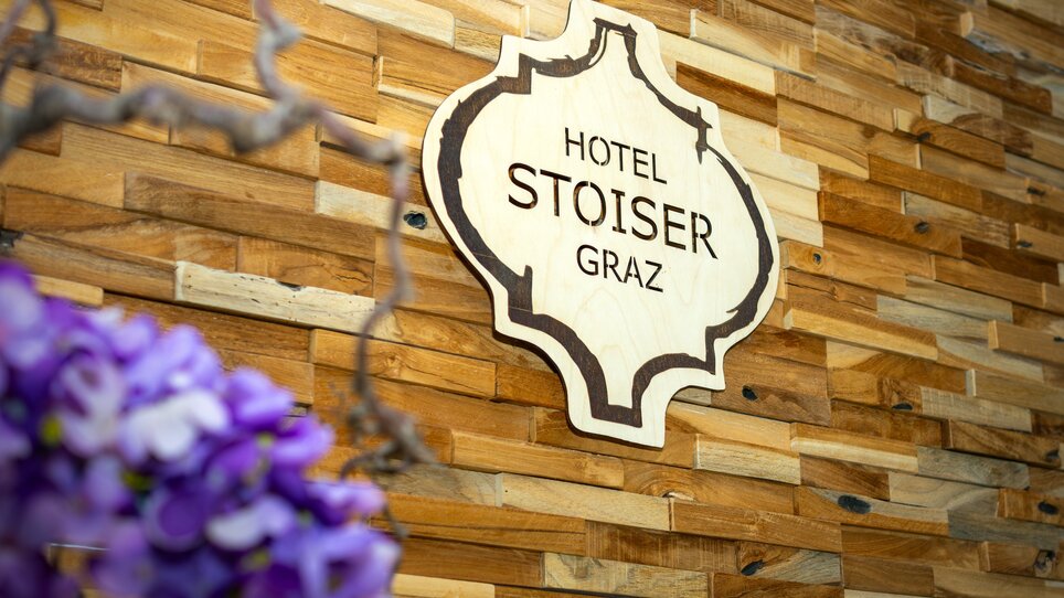 Sign of Hotel Stoiser Graz on a wooden wall. | © Hotel Stoiser Graz