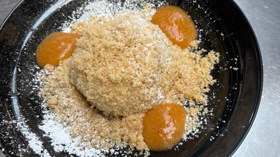 Ein Dessert mit Marillenknödeln unter einem Berg aus feinen Keksbröseln, umgeben von Fruchtpüree serviert im Stubenberghaus. | © Stubenberghaus
