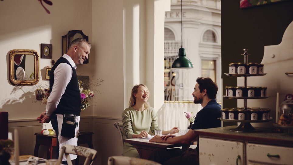 Pärchen im Restaurant mit Kellner, fröhliche Stimmung. | © Florian Weitzer Hotels & Restaurants