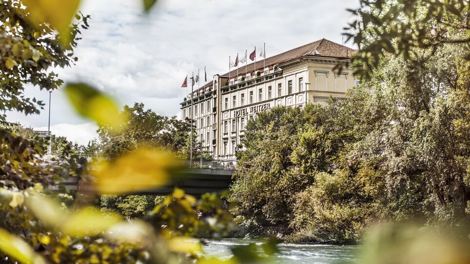 Der Blick auf das Hotel Das Weitzer in Graz, umrahmt von Bäumen und der Mur. | © Florian Weitzer Hotels & Restaurants