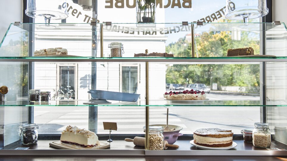 Vitrine mit verschiedenen Kuchen und Torten im Fenster des Cafés im Hotel Das Weitzer in Graz. | © Florian Weitzer Hotels & Restaurants