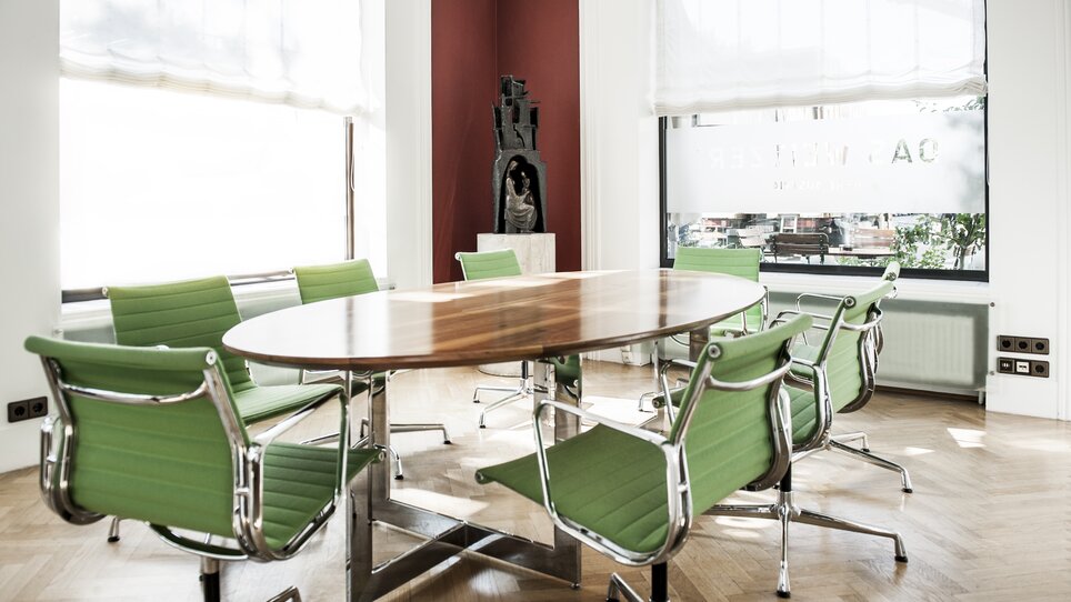 Besprechungsraum mit ovalem Tisch und grünen Stühlen im Hotel Das Weitzer, ideal für Tagungen und Veranstaltungen. | © Florian Weitzer Hotels & Restaurants