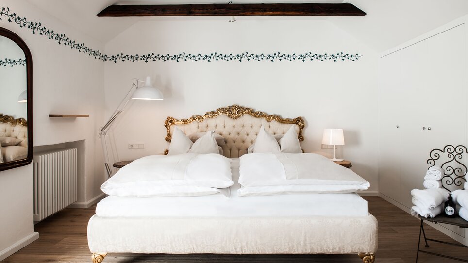 Behagliches Zimmer  im Hotel Das Weitzer mit elegantem Bett und dekorativen Elementen. | © Florian Weitzer Hotels & Restaurants