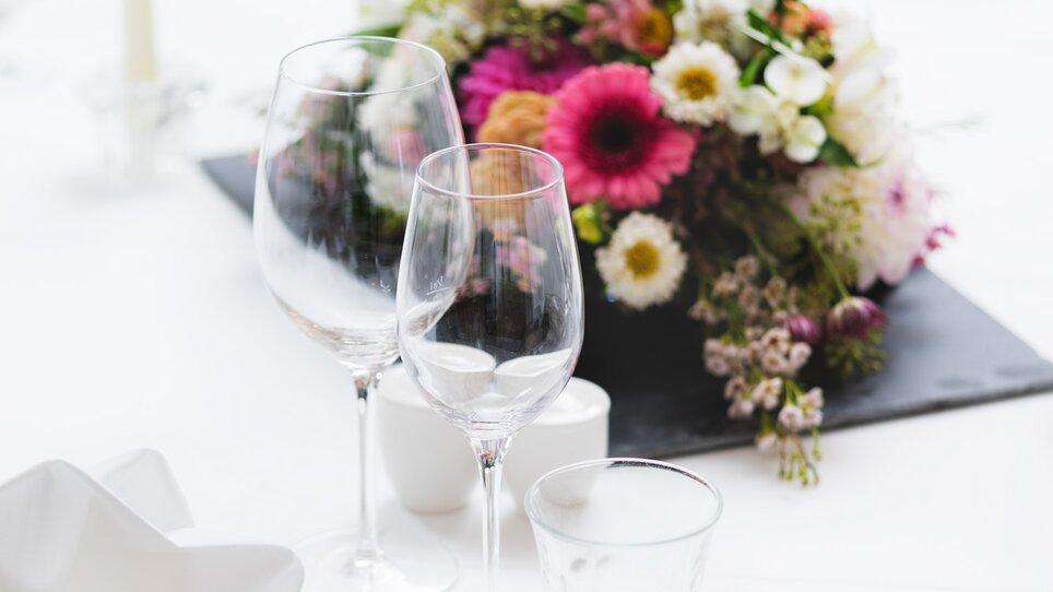 Festlich gedeckter Tisch im Grand Hôtel Wiesler mit Blumenarrangement und Gläsern. | © Florian Weitzer Hotels & Restaurants