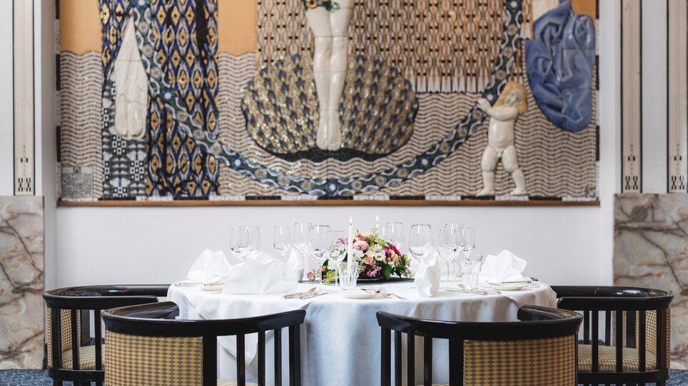Eleganter gedeckter Tisch im Grand Hôtel Wiesler, mit Kunstwerk im Hintergrund. | © Florian Weitzer Hotels & Restaurants