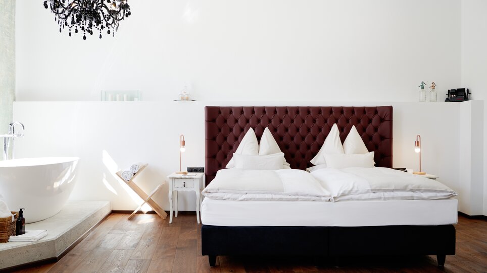 Schlafzimmer im Grand Hôtel Wiesler mit Doppelbett und freistehender Badewanne. | © Florian Weitzer Hotels & Restaurants