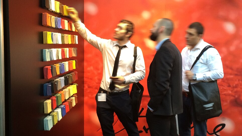 Fachbesucher analysieren Auswahl an Lederfarben bei Boxmark Leather auf einer Messe in Graz, Österreich. Die Präsentation ist ansprechend gestaltet.