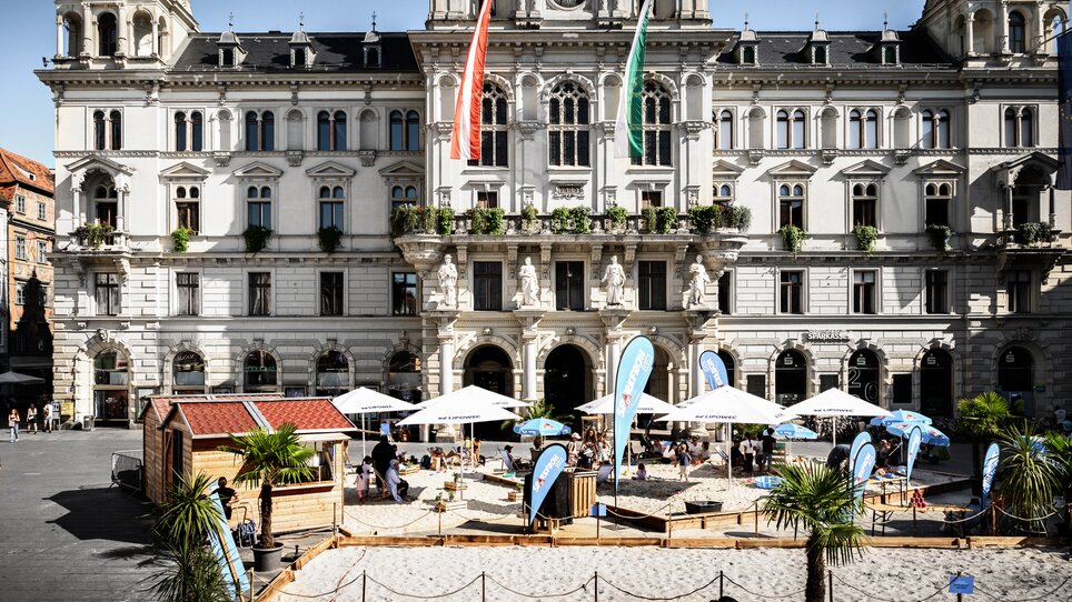 Familien bei Strandaktivitäten vor historischem Gebäude in Graz. | © Ulrike Rauch