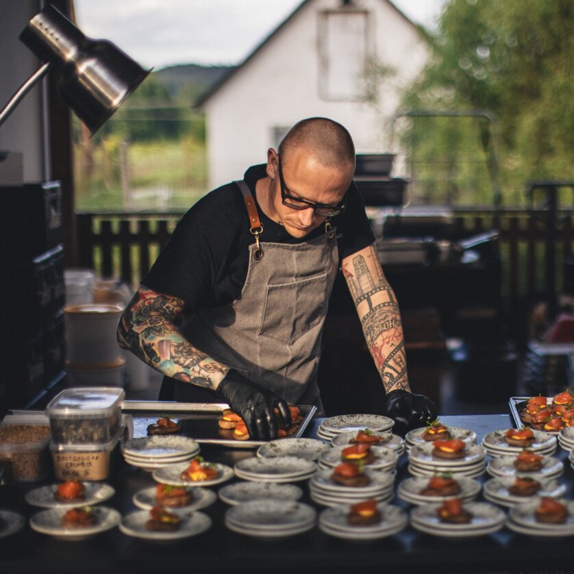 Zwei Köche von The Underground Kitchen // bereiten kunstvolle Häppchen in einer lichtdurchfluteten Küche vor. Fokus auf High-End-Tellerpräsentation und professioneller Atmosphäre. | © Alex Rauch