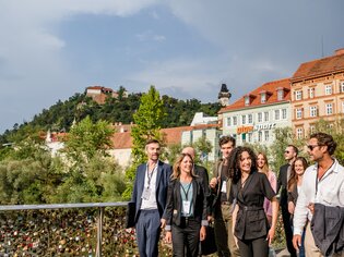 Geschäftsleute in Graz, Fluss Mur im Hintergrund, Uhrturm sichtbar. Tagung in moderner Umgebung. | © Graz Tourismus - Mias Photoart