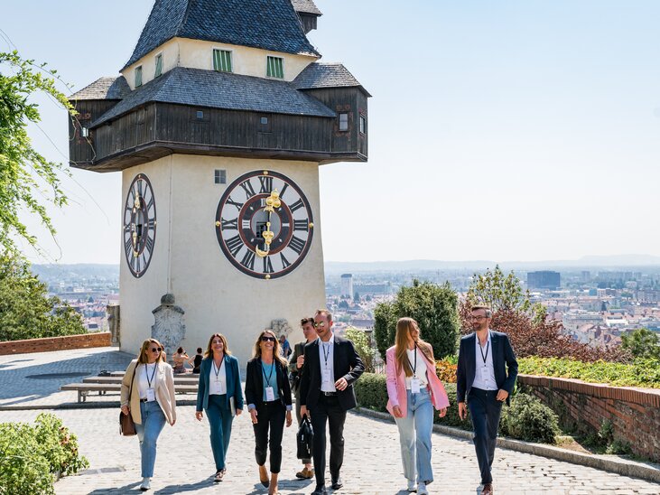 Group of business travelers at the Graz Clock Tower in the city of Graz. | © Graz Tourismus - Mias Photoart