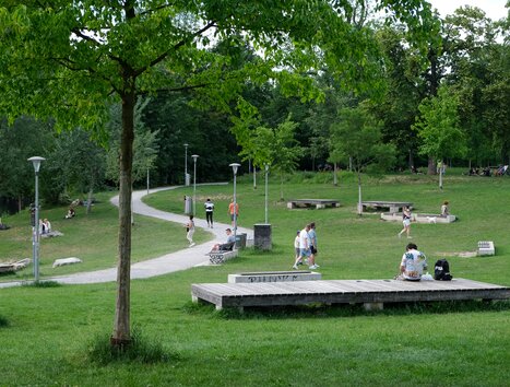 Menschen gehen und entspannen im Augartenpark, umgeben von Bäumen und Rasen. | © putopis - Jasminka Dagovic