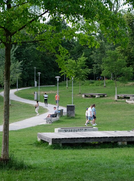 People walking and relaxing in the Augartenpark surrounded by trees and grass. | © putopis - Jasminka Dagovic
