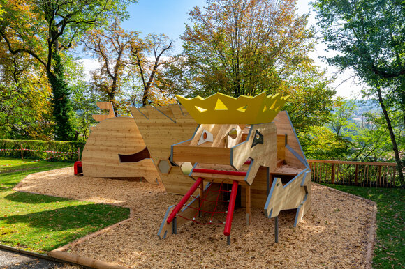 Ein kreatives Spielgerät in einem Park, umgeben von Bäumen und Holzschnitzeln. | © Graz Tourismus - Harry Schiffer