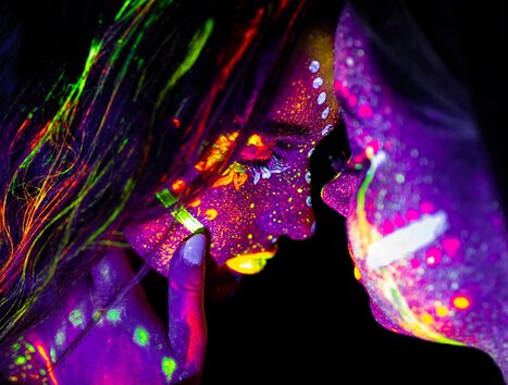 Zwei Gesichter, bemalt mit fluoreszierenden Farben, stehen sich gegenüber. | © pixabay