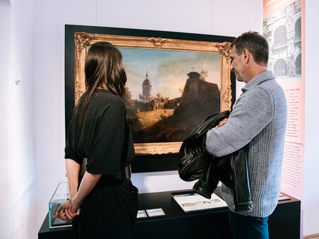 Ein Paar im Museum betrachtet ein Gemälde mit einer schönen Landschaft. | © Graz Tourismus