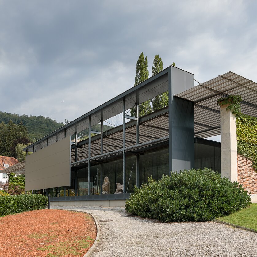 Ein minimalistisches Gebäude mit Glas und Stahl in Graz, umgeben von Grünflächen. | © Universalmuseum Joanneum - N. Lackner
