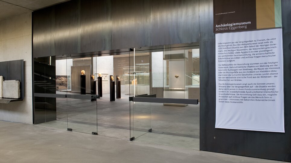Moderne Glaseingangstür zum Archäologiemuseum mit Ausstellungen. | © UMJ - N. Lackner