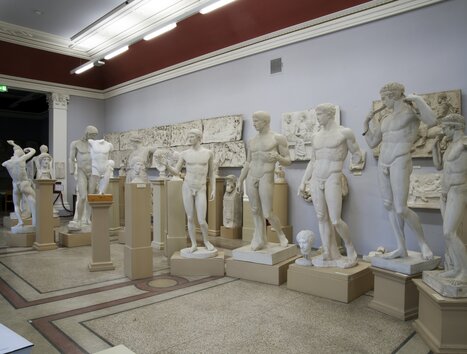 A room featuring various white sculptures and reliefs. | © Institut für Archäologie