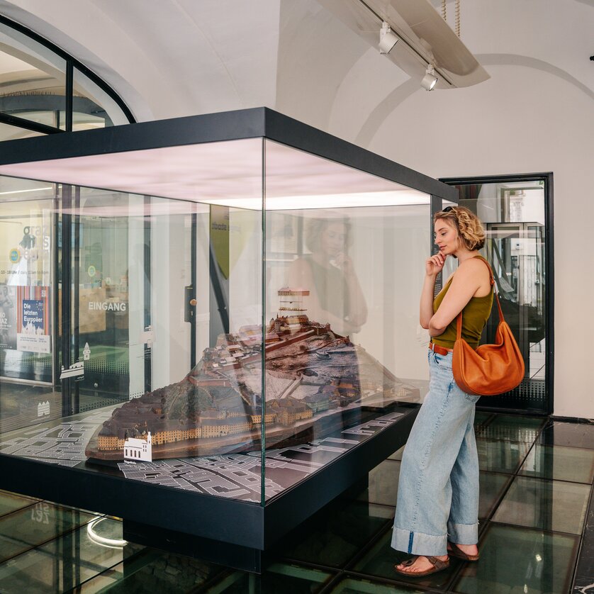 Frau betrachtet ein Modell im Graz Museum. | © Graz Tourismus - Mias Photoart
