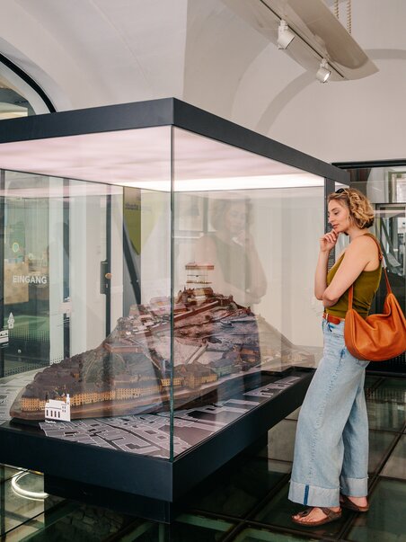Woman looking at a model in the Graz Museum. | © Graz Tourismus - Mias Photoart