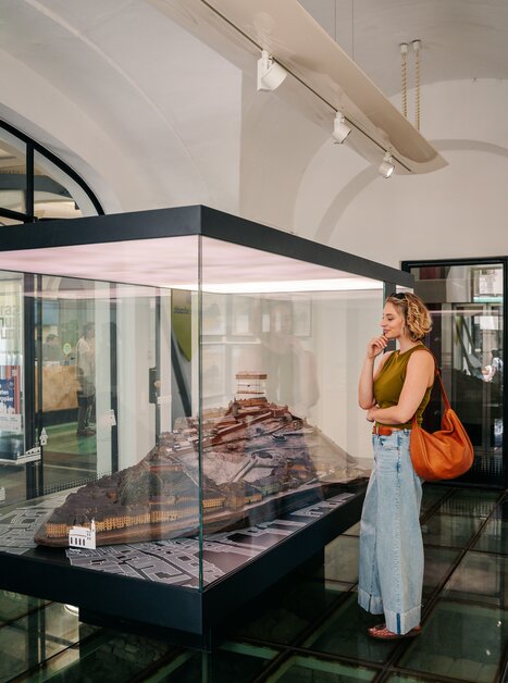 Eine Frau betrachtet ein Modell von Graz im Graz Museum. | © Graz Tourismus - Mias Photoart