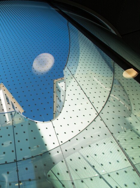 Blick durch einen Glasbogen auf das Joanneumsviertel in Graz. | © Graz Tourismus - Harry Schiffer