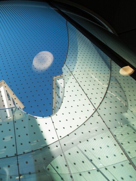 Blick durch einen Glasbogen auf das Joanneumsviertel in Graz. | © Graz Tourismus - Harry Schiffer