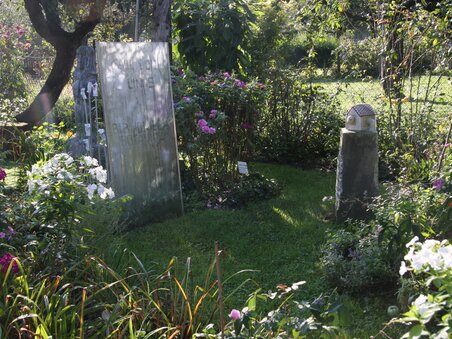 Ein Garten mit Grabsteinen und bunten Blumen. | © kunstGarten