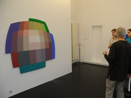 Visitors observing a geometric color artwork in the museum. | © MUWA