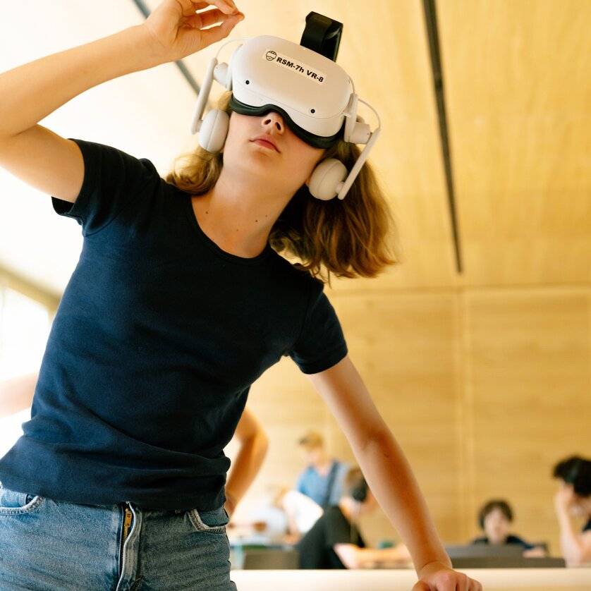 Ein Kind trägt ein VR-Headset und erkundet eine digitale Umgebung.
