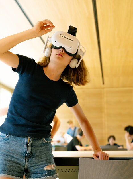 Ein Kind trägt ein VR-Headset und erkundet eine digitale Umgebung.